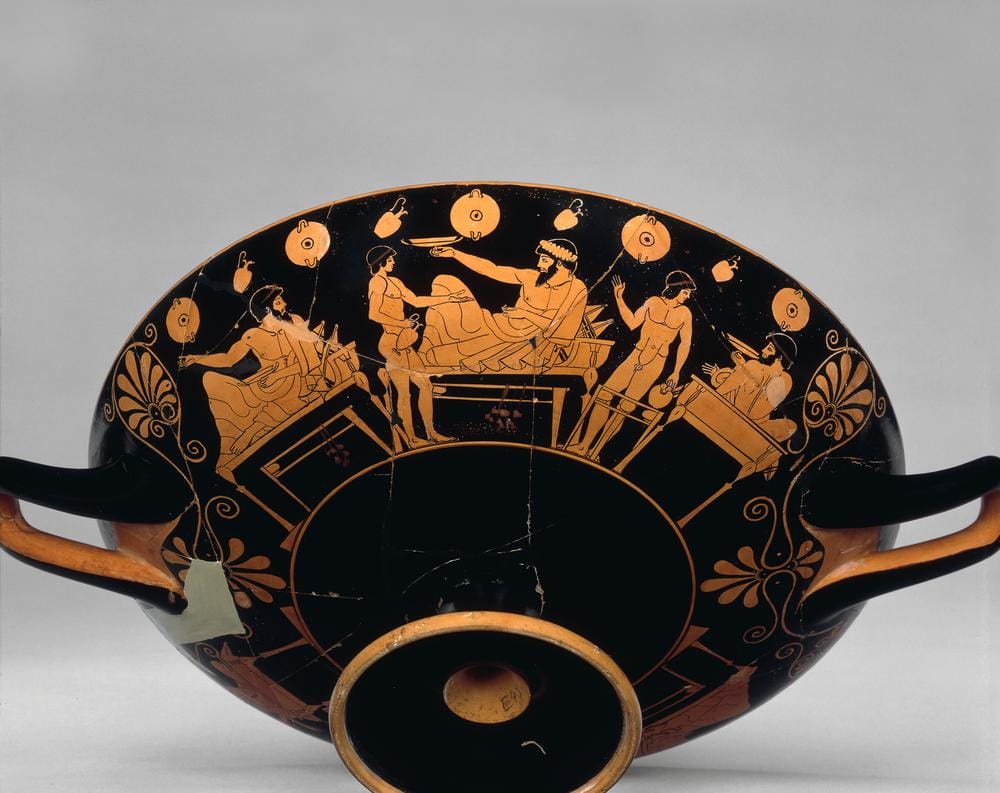 Athenian red-figure drinking cup depicting a reclining banqueter playing kottabos