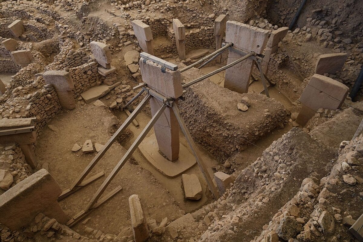 Two central T-shaped pillars in Enclosure D with arms and belts in low relief.