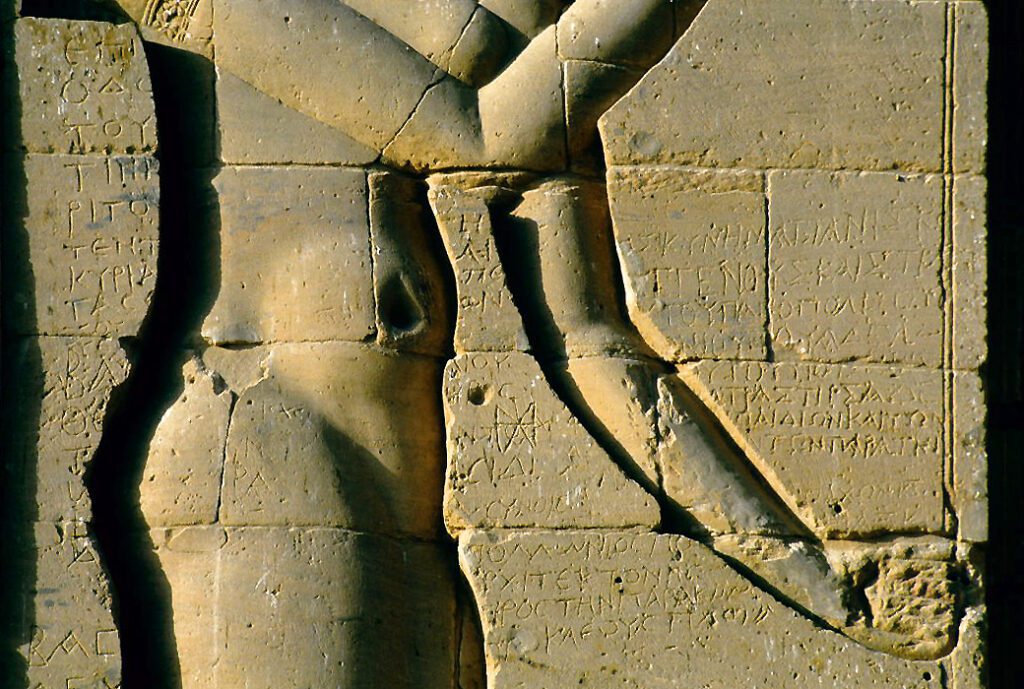 Greek-letter names and symbols incised on a column at Philae, with a small barque motif.