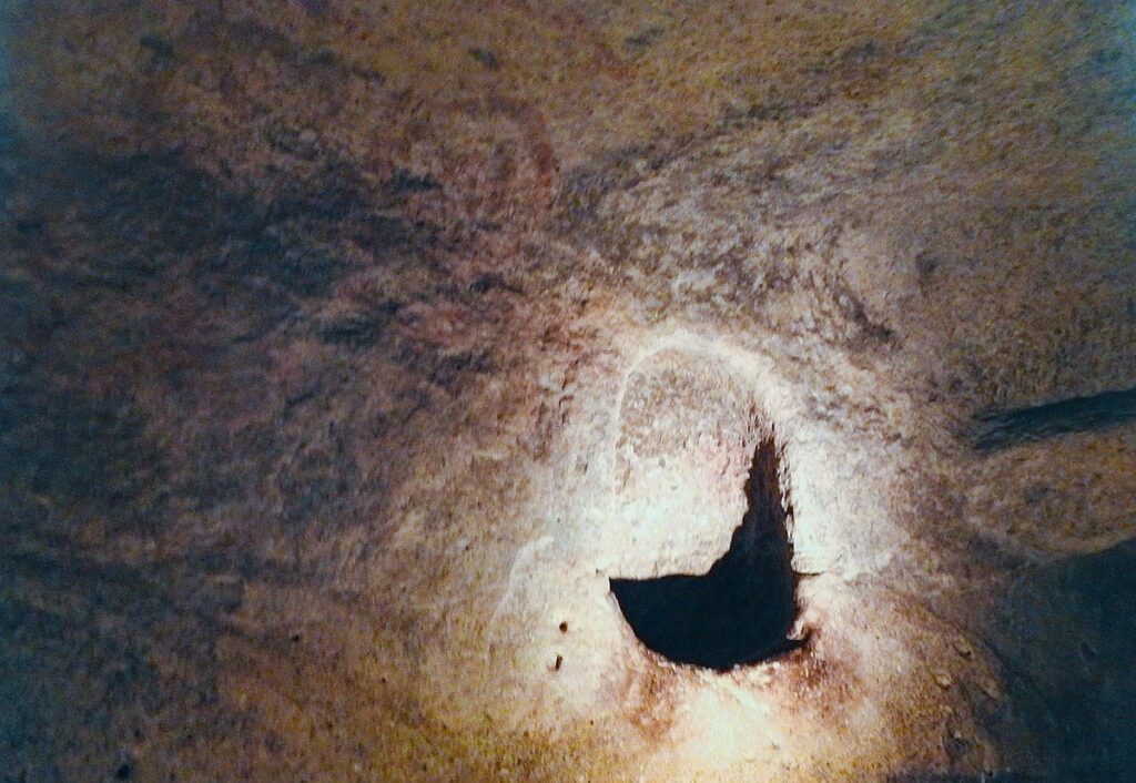 Interior of the Hypogeum's Oracle Room with the small aperture and red-ochre motifs.
