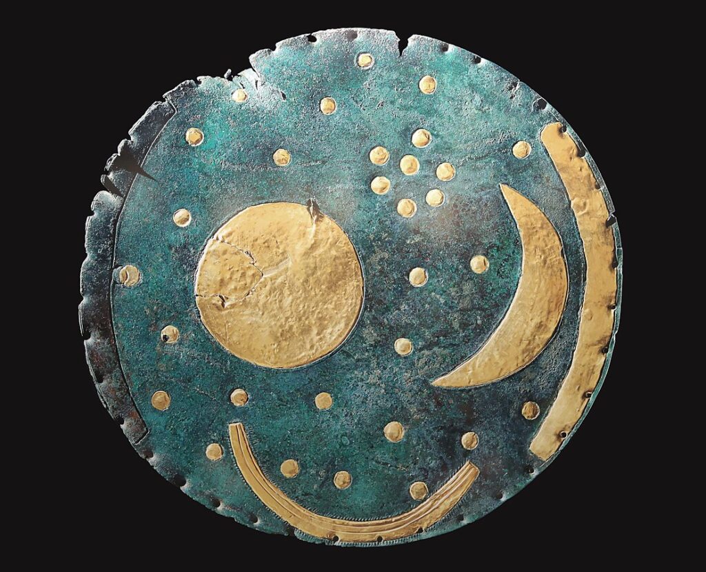 The Nebra Sky Disc showing bronze plate with gold inlays of stars, crescent moon, and horizon arcs.