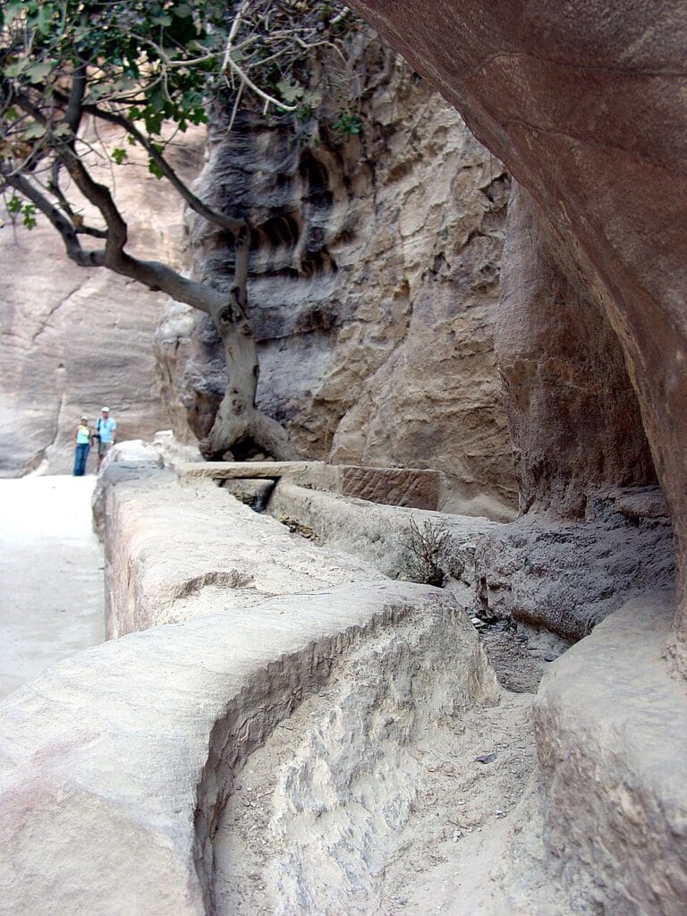 Ancient Infrastructure in Petra with rock-cut gutters lining the Siq approach