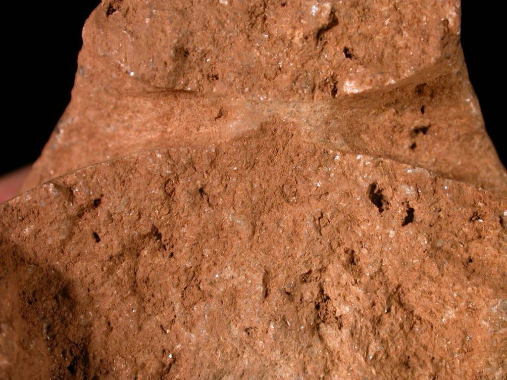 Close view of a two-part stone mould for casting a socketed axe, showing runner and vent.