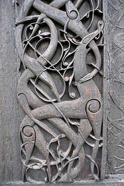 Stave church portal carving with a bound wolf motif