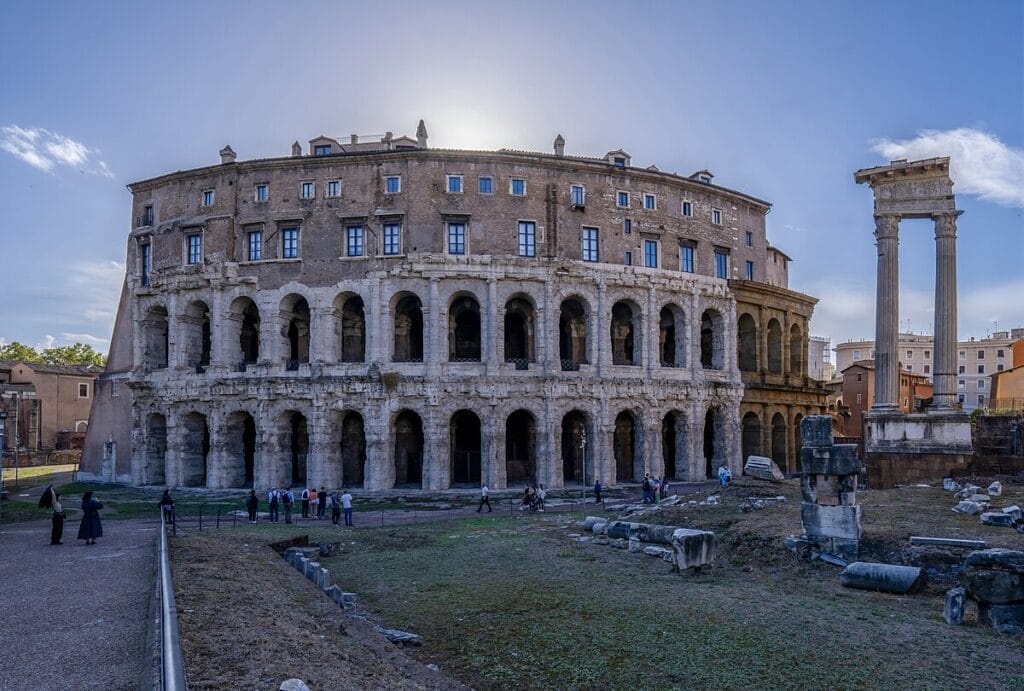 Exterior view of the Theatre of Marcellus in Rome with arcades and modern street.