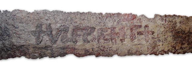 Ulfberht sword displayed in a museum case, with clear inlay and fine steel work showing its prestige quality.